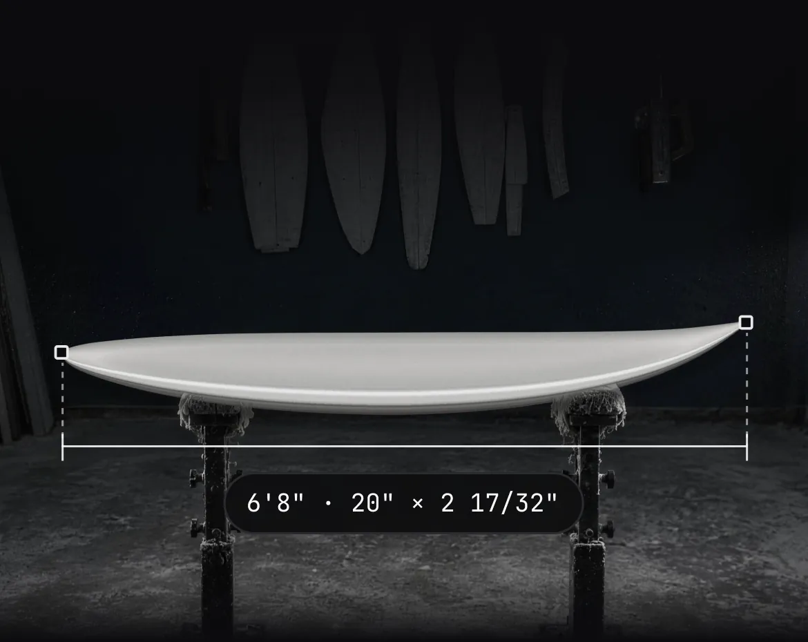 A finished 6'8" board on shaping stands in a dark shaping bay, with its length measured